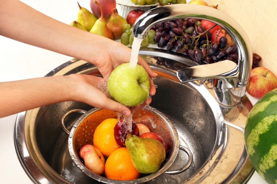womans-hands-washing-apple-and-other-fruits-in-colander-in-sink-2BGW4RJ